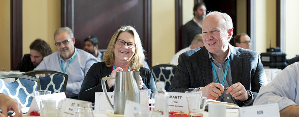 Two people sitting at a table at a CISR event 